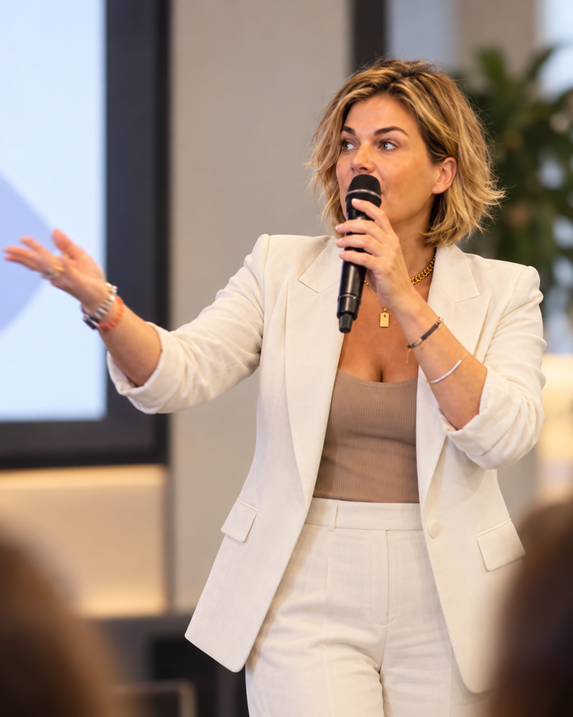 Hannah speaking to a room with a handheld mic