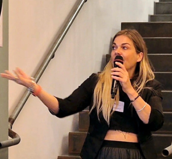 Hannah on stage against a brick wall